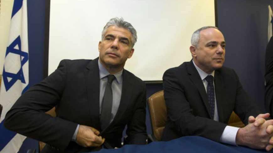 Outgoing Israeli Finance Minister Yuval Steinitz (R) sits next to incoming Finance Minister Yair Lapid during a changeover ceremony in Jerusalem March 19, 2013. Lapid, who once told Prime Minister Benjamin Netanyahu he didn't "know anything about economics," has a golden opportunity to push through much-needed structural reforms to lower the deficit and boost the economy. REUTERS/Ronen Zvulun (JERUSALEM - Tags: POLITICS BUSINESS) - RTR3F6R5