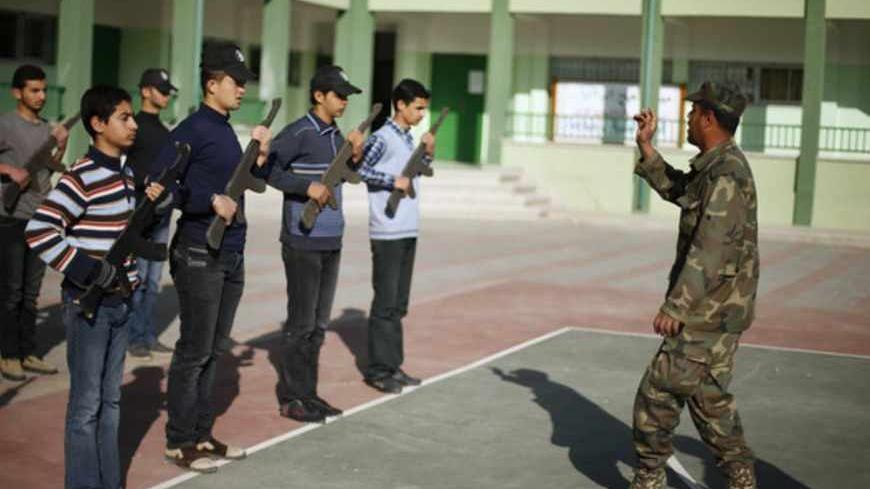 A member of Hamas security forces gives instructions to Palestinian students during a military-style exercise at the courtyard of a high school in Khan Younis in the southern Gaza Strip March 6, 2013. The military-style exercise in the 138 Hamas-run high schools in Gaza was part of a program sanctioned by the Hamas Islamist government to teach students how to use guns. Education officials in Gaza say some 6,000 students have joined the training initiative where only boys can sign up for the voluntary progra