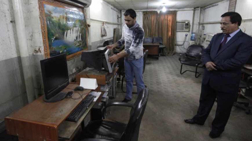 Iraqi journalists inspect the equipment after attack by an armed group at the newspaper's headquarters of Addustour newspaper in Baghdad April 2, 2013. Employees of Iraq's Addustour newspaper on Tuesday  inspected the damage caused by an armed group attack at the newspaper's headquarters the day before. The armed group broke into the newspaper building in Karrada district in central Baghdad on Monday, beating guards and journalists and burning editions of the newspaper, said an eyewitness.REUTERS/Thaier al-