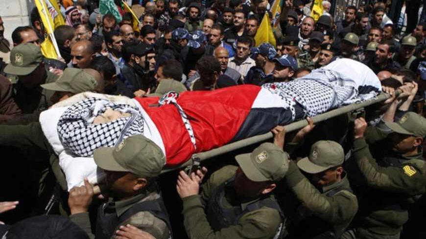 Members of the Palestinian security forces carry the body of Maysara Abu Hamdeya during his funeral in the West Bank city of Hebron April 4, 2013. Thousands of mourners turned out on Thursday for the funerals of three Palestinians, including two teenagers killed by Israeli army gunfire in some of the worst violence in the occupied West Bank in years. The upsurge in unrest was triggered on Tuesday by the death of Hamdeya, a 64-year-old prisoner serving a life term in an Israeli jail and suffering from cancer