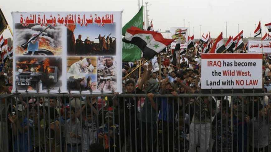 Iraqi Sunni Muslims take part in an anti-government demonstration in Falluja, 50 km (31 miles) west of Baghdad April 12, 2013. Thousands of Sunni Muslims protested after Friday prayers in huge rallies against Shi'ite Iraqi Prime Minister Nuri al-Maliki, demanding that he steps down. The poster (L) reads "Fallujah is spark of the resistance and spark of the revolution". REUTERS/Mohanned Faisal (IRAQ - Tags: CIVIL UNREST RELIGION POLITICS) - RTXYIVR