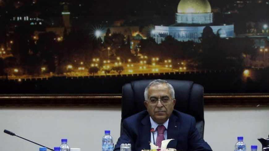 Palestinian Prime Minister Salam Fayyad sits at the head of a Palestinian cabinet meeting in the West Bank city of Ramallah April 16, 2013. Abbas accepted Fayyad's resignation on Saturday, but is likely to keep him in office for the next few weeks while the U.S. tries to revive Middle East peace talks, officials said on Monday. REUTERS/ Mohamed Torokman (WEST BANK - Tags: POLITICS) - RTXYNV1
