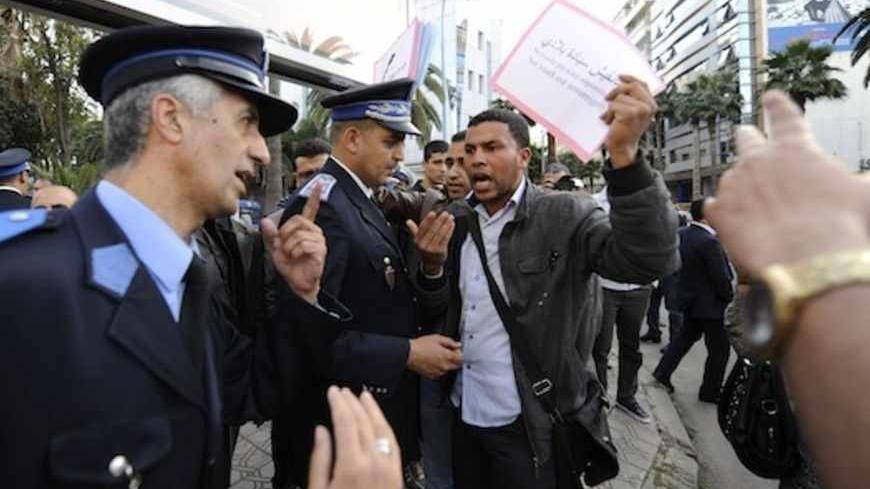 A protester argues with police officers as he protests against U.S.-backed plans to broaden the mandate of UN peacekeepers in the disputed Western Sahara, in Casablanca April 22, 2013.   REUTERS/Youssef Boudlal (MOROCCO - Tags: POLITICS CIVIL UNREST) - RTXYW4L