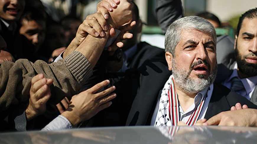 Palestinian students hold the hand of Hamas chief Khaled Meshaal (2nd R) during his visit to the Islamic University in Gaza City December 9, 2012. Meshaal, in a defiant speech during his first ever visit to Gaza, told a mass rally on Saturday he would never recognise Israel and pledged to "free the land of Palestine inch by inch". REUTERS/Suhaib Salem (GAZA - Tags: POLITICS ANNIVERSARY CIVIL UNREST) - RTR3BDJP