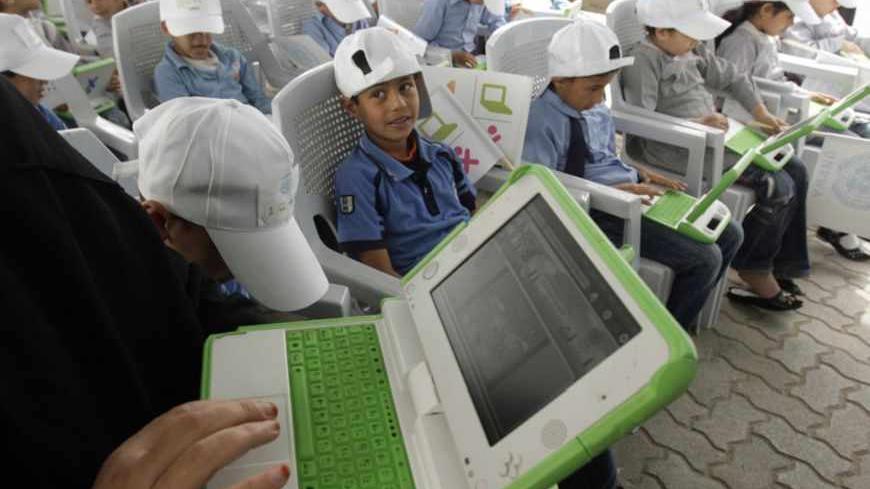 A teacher shows Palestinian students how to use new laptops at a United Nations school in Rafah refugee camp in the southern Gaza Strip April 29, 2010. The United Nations Relief and Works Agency (UNRWA) launched a campaign to distribute some 200,000 laptops to UNRWA students in the Gaza Strip, an UNRWA official said. REUTERS/Ibraheem Abu Mustafa (GAZA - Tags: POLITICS EDUCATION) - RTR2D9BM