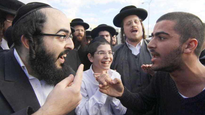 An ultra-Orthodox Jewish man (L) argues with a secular man during a protest against the government's pledge to curb Jewish zealotry in Israel, in the town of Beit Shemesh, near Jerusalem December 26, 2011. Israeli police arrested several ultra-Orthodox protesters on Monday after an officer was injured in the demonstrations in the divided city over demands by zealots to restrict access by women to certain streets. REUTERS/Oren Nahshon (ISRAEL - Tags: POLITICS RELIGION CIVIL UNREST TPX IMAGES OF THE DAY) ISRA