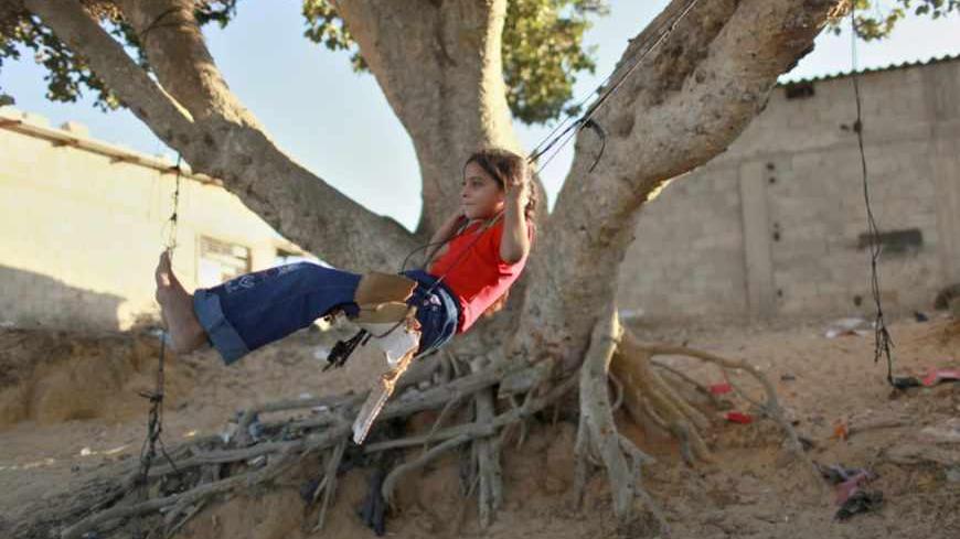 A Palestinian girl plays on a makeshift swing in Khan Younis in the southern Gaza Strip September 23, 2012.  REUTERS/Mohammed Salem (GAZA - Tags: SOCIETY) - RTR38BK0
