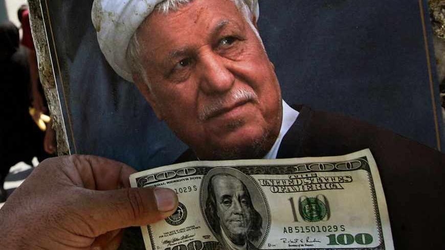 Iranian supporter of presidential candidate Rafsanjani puts US bill in front of pre-election poster outside Tehran's bazaar.   An Iranian supporter of presidential candidate Akbar Hashemi Rafsanjani puts a US$100 bill in front of his pre-election poster outside Tehran's bazaar June 7, 2005. Tehran's bazaar is a bastion of conservative power in the Islamic Republic and played a leading role in the 1979 Islamic revolution. But merchants know their traditional trading methods are threatened by attempts to mode