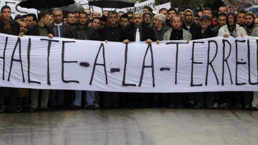Residents from the Berber region and regional party officials protest against extortion tactics employed by al Qaeda's north African wing, in Freha village, in the mountainous Kabylie region, 130km east of Algiers November 22, 2010. About 2,500 people demonstrated in a remote part of Algeria on Monday to demand that security forces do more to protect them from al Qaeda-linked militants who use the area as a stronghold. The banner reads, "Stop the terror".    REUTERS/Zohra Bensemra (ALGERIA - Tags: POLITICS 