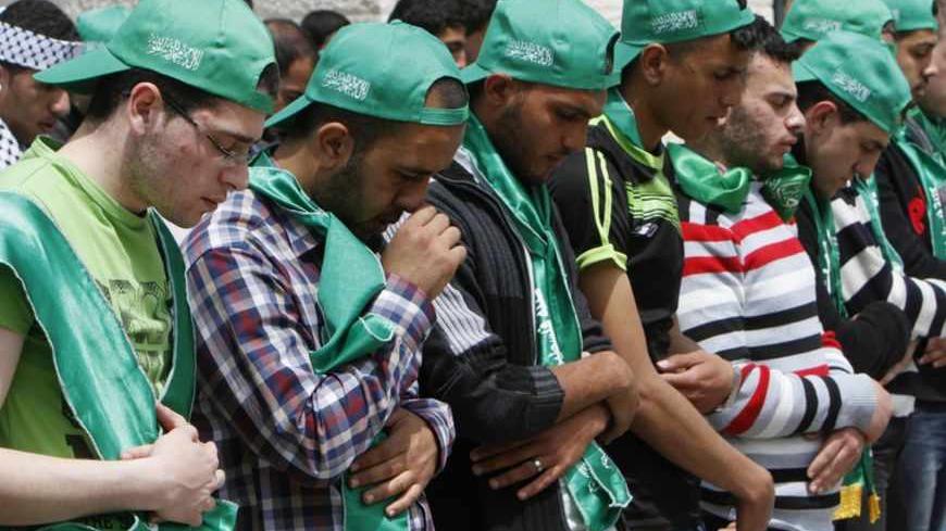Palestinian students wearing Hamas hats pray at al-Najah University campus in the West Bank city of Nablus, on the day of the student council elections, April 23, 2013. While Palestianian politics may be in a moribund condition at the national level, the paralysis has not stifled youthful debate. The main university of Nablus was a riot of yellow and green flags, the colours of Fatah and Hamas, on the day of the elections. Picture taken April 23, 2013. To match ISRAEL-PALESTINIANS/YOUTH  REUTERS/Abed Omar Q