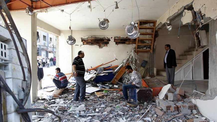 The owner of a shop and his family members wait in his damaged shop at the site of a twin bomb blast in the town of Reyhanli in Hatay province, near the Turkish-Syrian border May 14, 2013. REUTERS/Umit Bektas (TURKEY - Tags: POLITICS CIVIL UNREST) - RTXZLWK