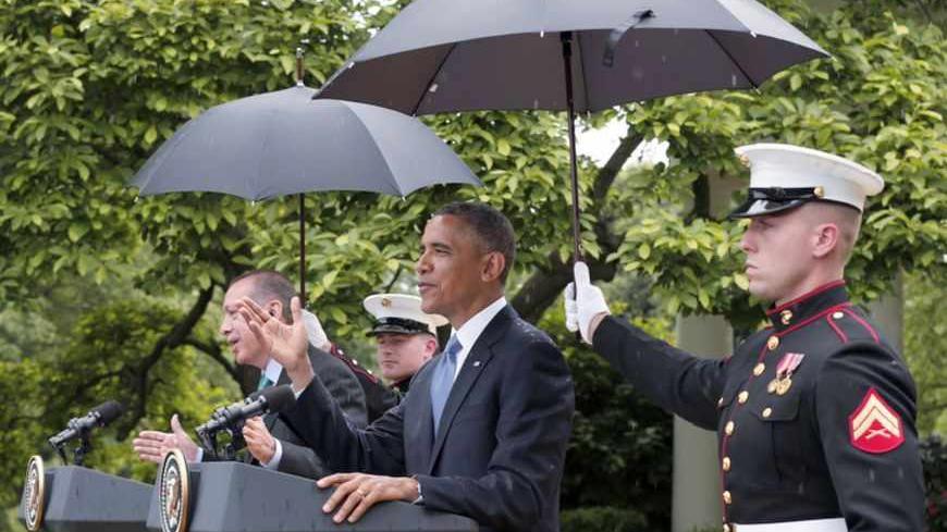U.S. Marines hold umbrellas as rain falls during a joint news conference between U.S. President Barack Obama (2ndR) and Turkish Prime Minister Recep Tayyip Erdogan (L) in the White House Rose Garden in Washington, May 16, 2013.   REUTERS/Kevin Lamarque (UNITED STATES  - Tags: POLITICS)   - RTXZPG3