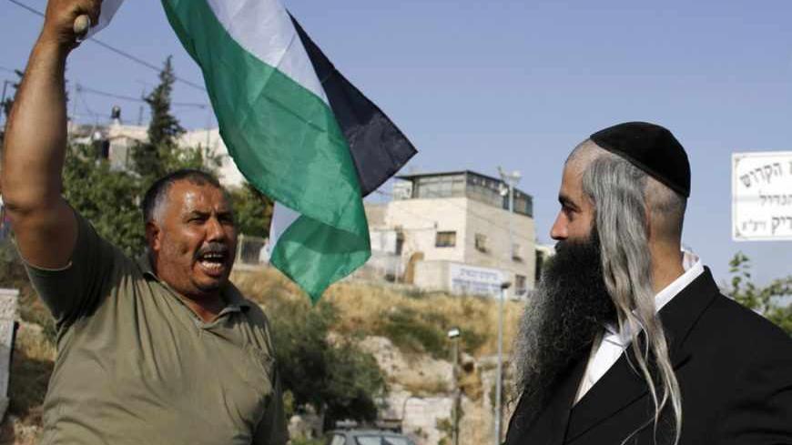 A protester waving a Palestinian flag shouts at an Orthodox Jewish man in the Sheikh Jarrah neighborhood of East Jerusalem May 17, 2013, during a weekly demonstration against Jewish settlements and the possible eviction of a Palestinian family from their home. REUTERS/Ammar Awad (JERUSALEM - Tags: POLITICS CIVIL UNREST) - RTXZQQB