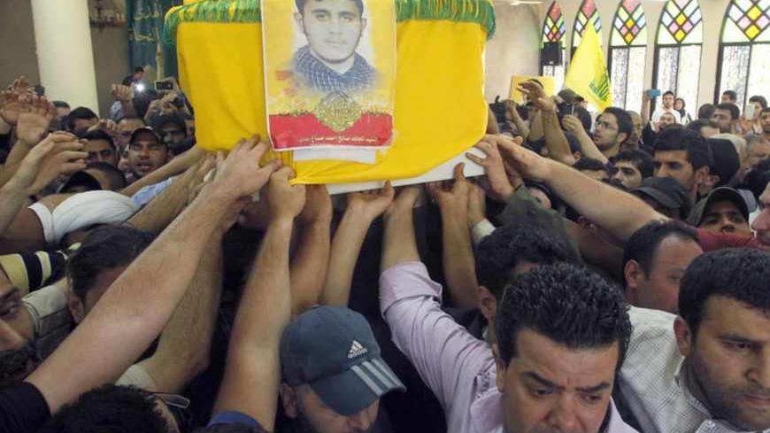Supporters of Hezbollah and relatives of Saleh Ahmed Sabagh, a Hezbollah member, carry the coffin during his funeral in the port-city of Sidon, southern Lebanon May 22, 2013. Syria's leading opposition group called on Wednesday for rebels across the country to send reinforcements to the strategic border town Qusair, where heavy fighting has drawn in fighters from Lebanon's powerful Hezbollah movement. REUTERS/Ali Hashisho (LEBANON - Tags: POLITICS CIVIL UNREST OBITUARY) - RTXZWIM