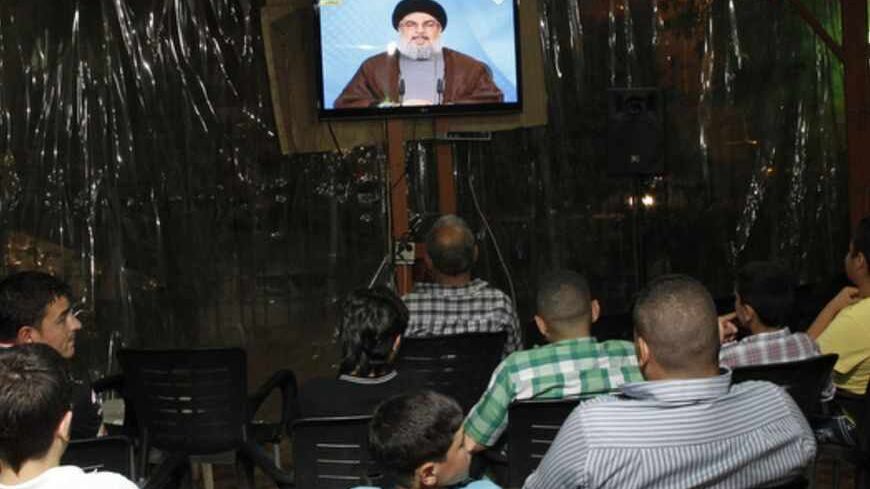 Lebanese men watch Hezbollah leader Hassan Nasrallah delivering a televised speech at a cafe in Beirut on April 30, 2013. The chief of powerful Lebanese Shiite Muslim party Hezbollah, a close Damascus ally, said that Syria's friends would not let the embattled regime of President Bashar al-Assad fall.  AFP PHOTO / ANWAR AMRO        (Photo credit should read ANWAR AMRO/AFP/Getty Images)