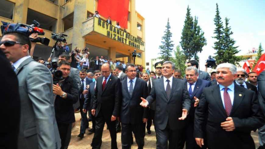 Turkish President Abdullah Gul waves as he visits the bomb scene on May 16, 2013 during the funerals of the victims of a car bomb which went off on May 11 at Reyhanli in Hatay just a few kilometres from the main border crossing into Syria. The death toll in twin car bombings in a Turkish town near the Syrian border has increased to 50 after another body was recovered and a victim died in hospital, the health minister was quoted as saying on May 14. The attacks also provoked a backlash against Syrian refugee