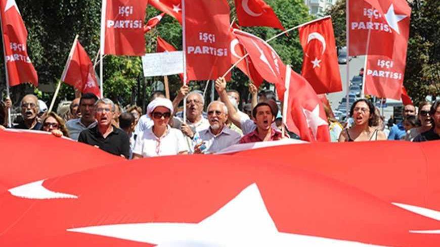 Members of the left wing Turkish group hold a national flag as they march to the U.S. embassy to protest against the visit of U.S. Secretary of State Hillary Clinton, in Ankara, on Agust 11, 2012.  Fresh sanctions slapped by the United States are meant to "expose and disrupt" links between Iran, Lebanon's armed Hezbollah movement and Syria, US Secretary of State Hillary Clinton said Saturday. AFP PHOTO/STR        (Photo credit should read STR/AFP/GettyImages)
