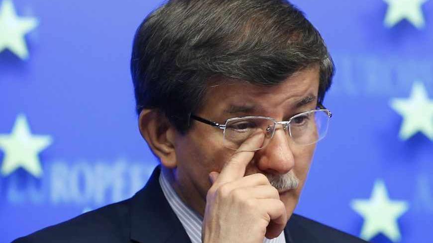 Turkey's Foreign Minister Ahmet Davutoglu wipes his eye as he addresses a news conference during an European Union-Turkey association council in Brussels May 27, 2013. REUTERS/Francois Lenoir (BELGIUM - Tags: POLITICS) - RTX102QD
