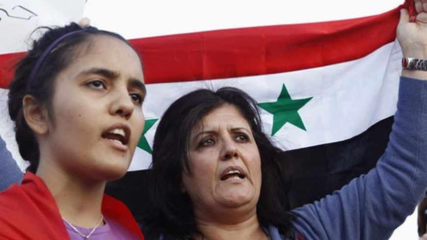 Jordanian activists hold a Syrian flag as they shout slogans against Israel during a protest to show their support to Syria's President Bashar al-Assad and condemning an air strike in Syria, near the Israeli embassy in Amman May 5, 2013. Israel carried out its second air strike in days on Syria early on Sunday, a Western intelligence source said, in an attack that shook Damascus with a series of powerful blasts and drove columns of fire into the night sky. REUTERS/Muhammad Hamed (JORDAN - Tags: POLITICS CIV