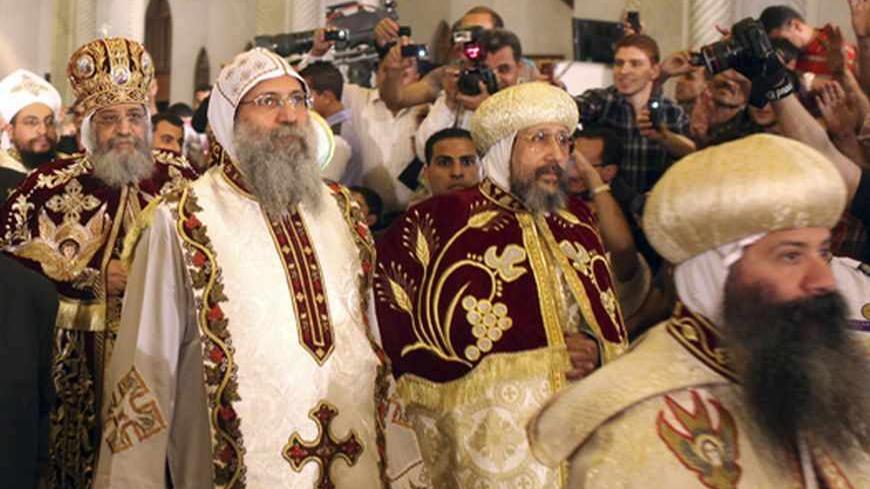 Egyptian Coptic Christians greet and take pictures of Coptic Pope Tawadros II (2nd L), head of the Coptic Orthodox church, as he arrives to celebrate a Coptic Orthodox Easter mass at Cairo's main cathedral May 4, 2013. REUTERS/Asmaa Waguih (EGYPT - Tags: RELIGION) - RTXZASF
