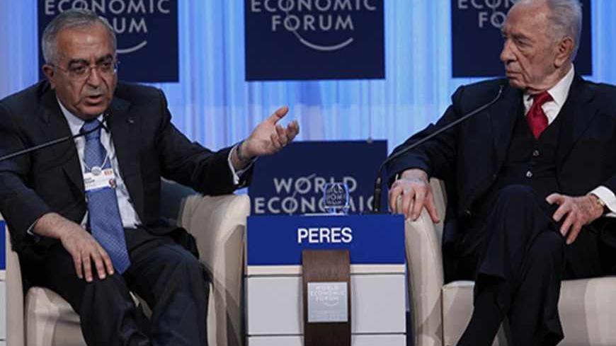 Palestinian Prime Minister Salam Fayyad (L) speaks next to Israel's President Shimon Peres during a session at the World Economic Forum (WEF) in Davos, January 26, 2012.             REUTERS/Arnd Wiegmann (SWITZERLAND  - Tags: POLITICS BUSINESS)   - RTR2WWBB