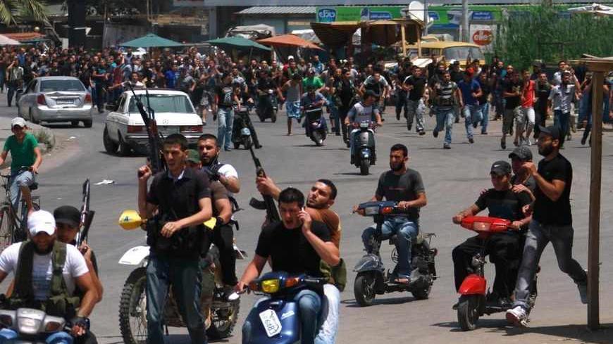 Lebanese Sunni gunmen ride on motorcycles during the funeral of one of their colleagues  in Lebanon's northern city of Tripoli May 20, 2013. Three people have been killed and about 40 wounded in two days of fighting in Tripoli, security sources said on Monday, as sectarian violence spilled over from the civil war in Syria.  REUTERS/Omar Ibrahim (LEBANON - Tags: POLITICS CIVIL UNREST) - RTXZTWV