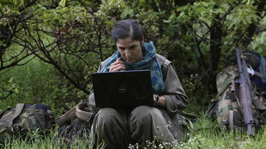 A member of Kurdistan Workers Party (PKK) works on her laptop in northern Iraq May 14, 2013. The first group of Kurdish militants to withdraw from Turkey under a peace process entered northern Iraq on Tuesday, and were greeted by comrades from the Kurdistan Workers Party (PKK), in a symbolic step towards ending a three-decades-old insurgency. The 13 men and women, carrying guns and with rucksacks on their backs, arrived in the area of Heror, near Metina mountain on the Turkish-Iraqi border, a Reuters witnes