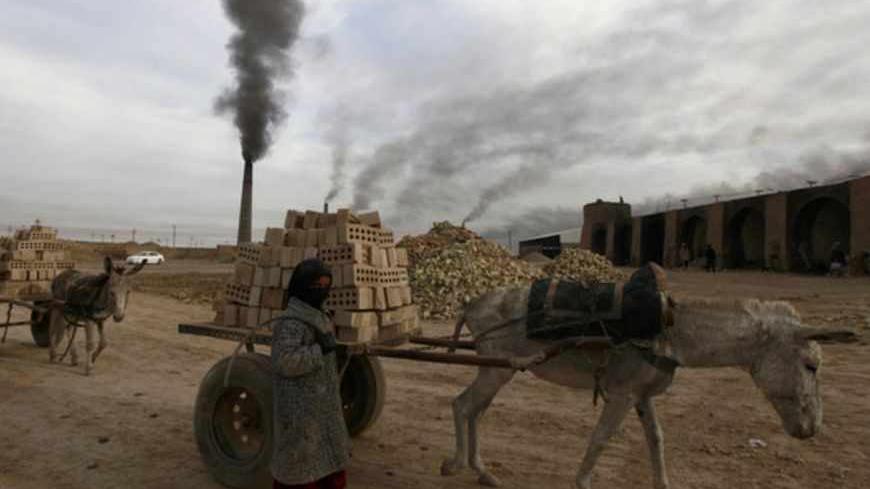 A girl works in a brick factory in the town of Nahrawan, east of Baghdad, March 8, 2012. REUTERS/Thaier al-Sudani (IRAQ - Tags : - Tags: SOCIETY BUSINESS EMPLOYMENT) - RTR2Z0ZC