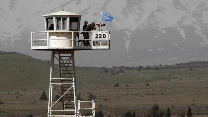 Soldiers of the U.N. Disengagement Observer Force (UNDOF), stand on an observation tower overlooking Syria and located on the Israeli side of the 1973 Golan Heights ceasefire line with Syria March 21, 2012. Blue-helmeted United Nations peacekeeping troops patrolling a slice of Syrian territory to maintain a ceasefire with Israel face new risks as violence between Syrian government loyalists and rebels gets closer. Picture taken March 21, 2012. REUTERS/Ronen Zvulun (POLITICS MILITARY CONFLICT) - RTR2ZRIQ