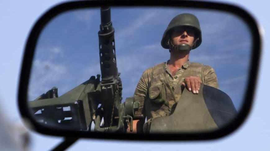A Turkish soldier is reflected on a mirror as he stands guard on top of an armoured personnel carrier on the Turkish-Syrian border near the Akcakale border crossing, southern Sanliurfa province, October 4, 2012. Turkey's parliament gave authorisation on Thursday for military operations outside Turkish borders if the government deemed them necessary, a day after artillery shelling from Syria killed five civilians in the Turkish town of Akcakale. REUTERS/Murad Sezer (TURKEY - Tags: POLITICS CONFLICT MILITARY)