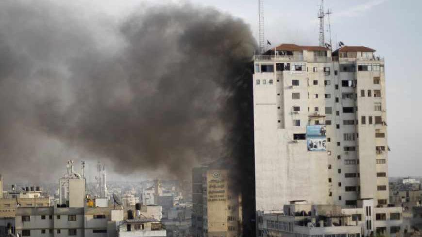 Smoke is seen after an after an Israeli air strike, witnessed by a Reuters journalist, out of a floor in a building that also houses media offices in Gaza City November 19, 2012. An Islamic Jihad local commander was killed on Monday in an Israeli air strike on a tower block that houses many international media, a source in the militant group said. REUTERS/Ahmed Jadallah  (GAZA - Tags: MILITARY CONFLICT MEDIA) - RTR3AM74