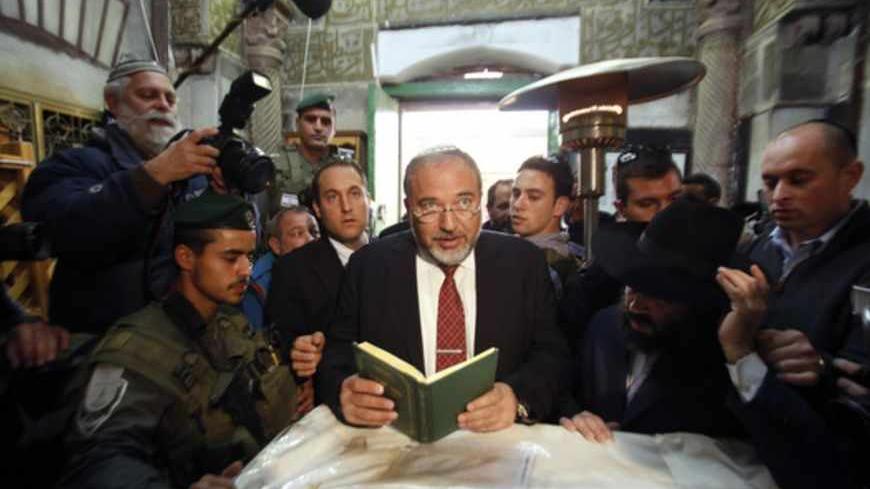 Israel's former Foreign Minister Avigdor Lieberman (C) prays during a visit to the Tomb of the Patriarchs in the West Bank city of Hebron January 14, 2013. Entrenched in what they view as their Biblical heartland, the hardline Jewish settlers of Hebron look forward with delight to next week's Israeli election. To match ISRAEL-ELECTION/SETTLERS     REUTERS/Baz Ratner (WEST BANK - Tags: POLITICS ELECTIONS RELIGION) - RTR3CG2V