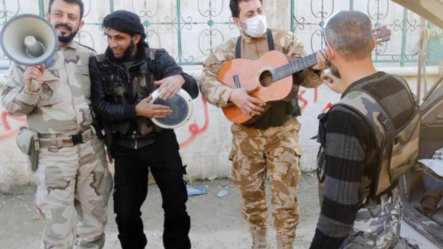 Members of the Free Syrian Army chant as one of them plays the guitar near Nairab military airport in Aleppo February 26, 2013.   REUTERS/Hamid Khatib    (SYRIA - Tags: CONFLICT POLITICS) - RTR3EBGO