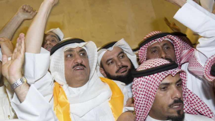 Kuwaiti former member of parliament and opposition politician Musallam al-Barrak (L) greets supporters from his house in Andulos, after a ruling sentenced him to jail for insulting the emir, April 15, 2013. Barrak was sentenced to five years in jail on Monday for insulting the emir, his lawyer said, in a ruling that brought thousands of people to the streets in protest. The Kuwaiti criminal court found Barrak guilty of insulting Sheikh Sabah al-Ahmad al-Sabah in a speech in October last year in which he app