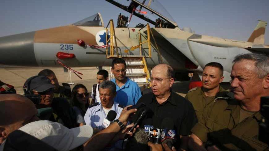 An Israeli Air Force F-15I jet is seen in the background as Israeli Defense Minister Moshe Yaalon (3rd R) speaks to reporters while standing next to Israel's armed forces chief Major-General Benny Gantz (R) and commander of Israel's Air Force Major-General Amir Eshel (4th R) during a presentation at Hatzerim air base in southern Israel April 30, 2013. Israel on Tuesday launched its first targeted attack on a militant in Gaza since a war in November, killing a Palestinian jihadist in an air strike that put f