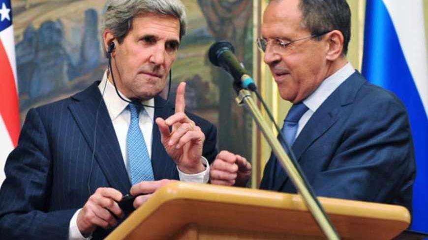 U.S. Secretary of State John Kerry (L) gestures as Russian Foreign Minister Sergei Lavrov tries to fix his translation equipment during a joint news conference after their meeting in Moscow May 7, 2013. Russia and the United States agreed on Tuesday to try to arrange an international conference this month on ending the civil war in Syria, and said both sides in the conflict should take part. REUTERS/Mladen Antonov/Pool (RUSSIA - Tags: POLITICS CONFLICT) - RTXZE4K