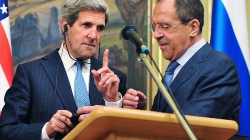 U.S. Secretary of State John Kerry (L) gestures as Russian Foreign Minister Sergei Lavrov tries to fix his translation equipment during a joint news conference after their meeting in Moscow May 7, 2013. Russia and the United States agreed on Tuesday to try to arrange an international conference this month on ending the civil war in Syria, and said both sides in the conflict should take part. REUTERS/Mladen Antonov/Pool (RUSSIA - Tags: POLITICS CONFLICT) - RTXZE4K