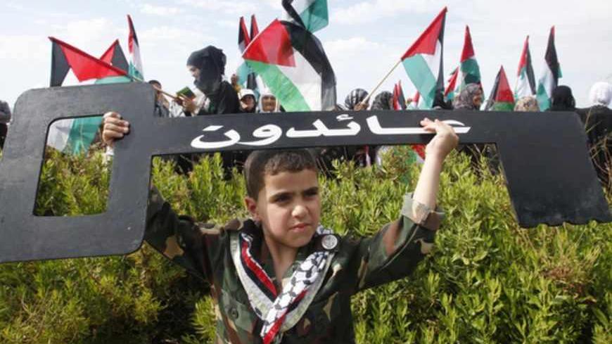 A Palestinian boy holds up a symbolic key during a march to mark the 65th anniversary of Nakba near the United Nations Interim Force in Lebanon (UNIFIL) headquarters in the town of Naqoura, in southern Lebanon near the border between Lebanon and Israel, May 13, 2013. Palestinians will mark "Nakba" (Catastrophe) on May 15 to commemorate the expulsion or fleeing of hundreds of thousands of their brethren from their homes in the war that led to the founding of Israel in 1948. REUTERS/Ali Hashisho (LEBANON - Ta
