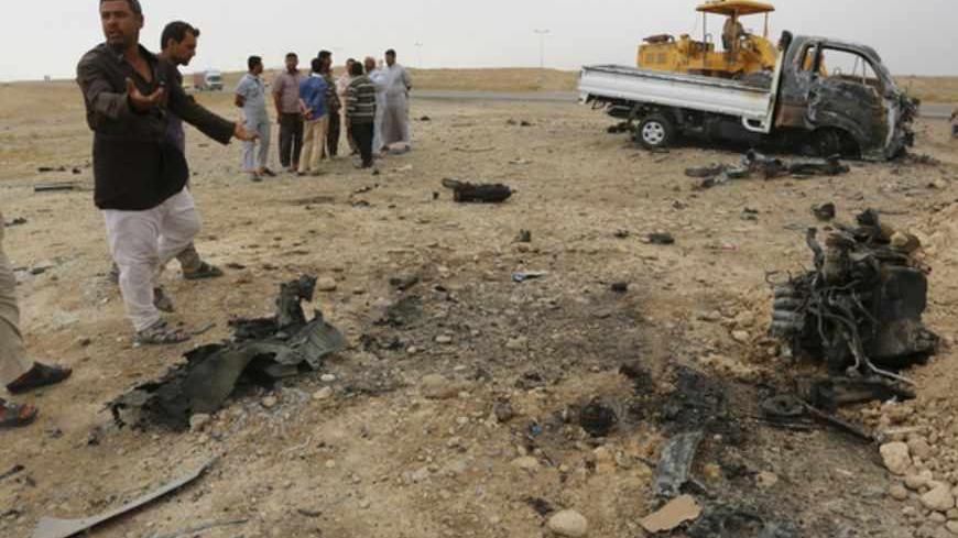 Civilians inspect the scene of a car bomb attack in Samarra, 100 km (62 miles) north of Baghdad, May 20, 2013. At least 43 people were killed in car bomb explosions targeting Shi'ite Muslims in the Iraqi capital and the southern oil hub of Basra on Monday, police and medics said. The attacks brought the number of people killed in sectarian violence in the past week to almost 200. Tensions between Shi'ites, who now lead Iraq, and minority Sunni Muslims have reached their highest level since U.S. troops pulle