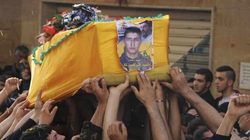 Supporters of Hezbollah and relatives of Hasan Faisal Sheker , an 18-year-old Hezbollah member, carry the coffin during his funeral in Nabi Sheet near Baalbeck May 20, 2013. About 30 Lebanese Hezbollah fighters and 20 Syrian soldiers and militiamen loyal to President Bashar al-Assad have been killed in the fiercest fighting this year in the rebel stronghold of Qusair, Syrian activists said on Monday. REUTERS/Stringer (LEBANON - Tags: POLITICS CIVIL UNREST) - RTXZU7Q