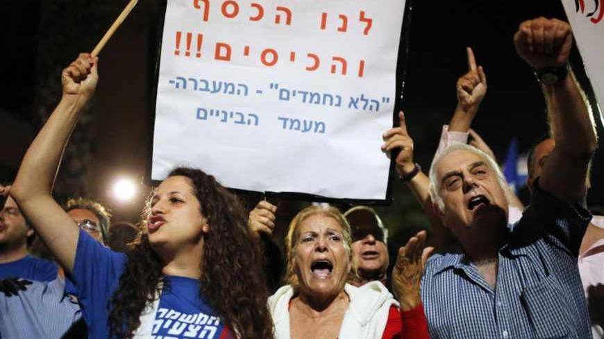 Potesters demonstrate against new austerity measures set to be included in the 2013-2014 national budget at a main junction in Tel Aviv May 11, 2013. Between 2,000 and 3,000 people demonstrated against the measures, which will be discussed by the Israeli cabinet on Monday. The sign in Hebrew reads, " They steal our money". REUTERS/ Amir Cohen (ISRAEL - Tags: BUSINESS POLITICS CIVIL UNREST) - RTXZJ79