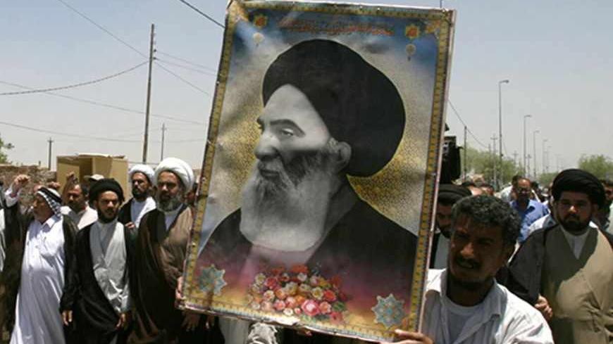Iraqis carry a poster of top Shi'ite cleric Grand Ayatollah Ali al-Sistani during a demonstration in Najaf, 160 km (100 miles) south of Baghdad June 13, 2007. Dozens of residents took to the streets in Najaf protesting the latest bomb attack in Samarra's Golden Mosque Shi'ite shrine.     REUTERS/Ali Abu Shish    (IRAQ) - RTR1QQY3
