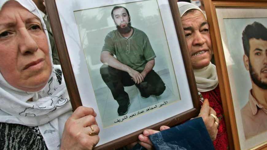 Palestinian women hold pictures of their sons during a protest calling for the release of Palestinian prisoners inside Israeli jails, in the West Bank city of Ramallah December 3, 2005. Candidates began signing up on Saturday for a Palestinian legislative election next month at which the ruling Fatah of President Mahmoud Abbas will face its first major challenge from powerful Islamist faction Hamas. REUTERS/Loay Abu Haykel - RTR1A0J5