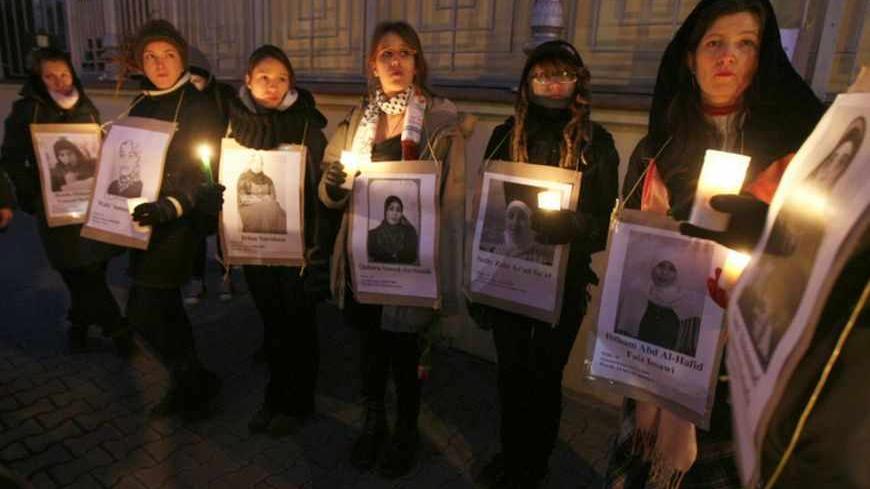 Demonstrators hold candles and pictures of arrested Palestinian women during a silent protest in front of the Israeli embassy in Warsaw March 8, 2011. A silent protest was organized during International Women day to remember 37 Palestinian political female prisoners kept in Israeli jails, organizers said. REUTERS/Kacper Pempel (POLAND - Tags: CIVIL UNREST POLITICS) - RTR2JMLP