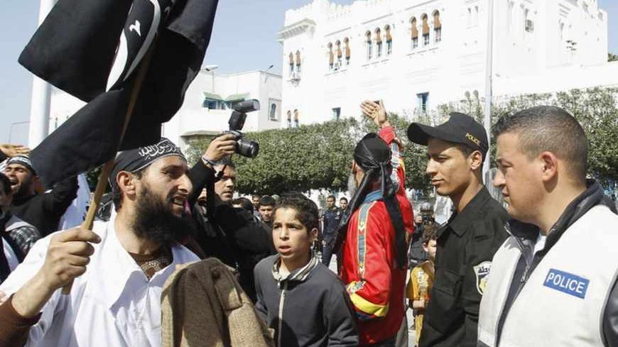 A salafist protester (L) gestures to riot police during a protest demanding for the inclusion of Islamic Law in the constitution in Tunis March 23, 2012.  REUTERS/Zoubeir Souissi (TUNISIA - Tags: POLITICS RELIGION CIVIL UNREST) - RTR2ZRUE
