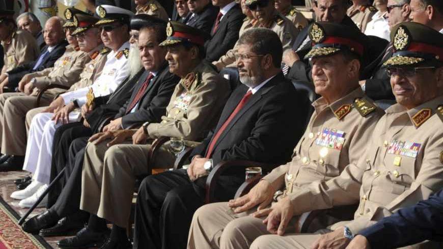 Egypt's new President Mohamed Mursi (3rd R) and Field Marshal Mohamed Tantawi (4th R), head of Egypt's ruling Supreme Council of the Armed Forces (SCAF), attend a ceremony where the military handed over power to Mursi at a military base in Hikstep, east of Cairo, June 30, 2012. Mursi was sworn in on Saturday as Egypt's first Islamist, civilian and freely elected president, reaping the fruits of last year's revolt against Hosni Mubarak, although the military remains determined to call the shots. The military