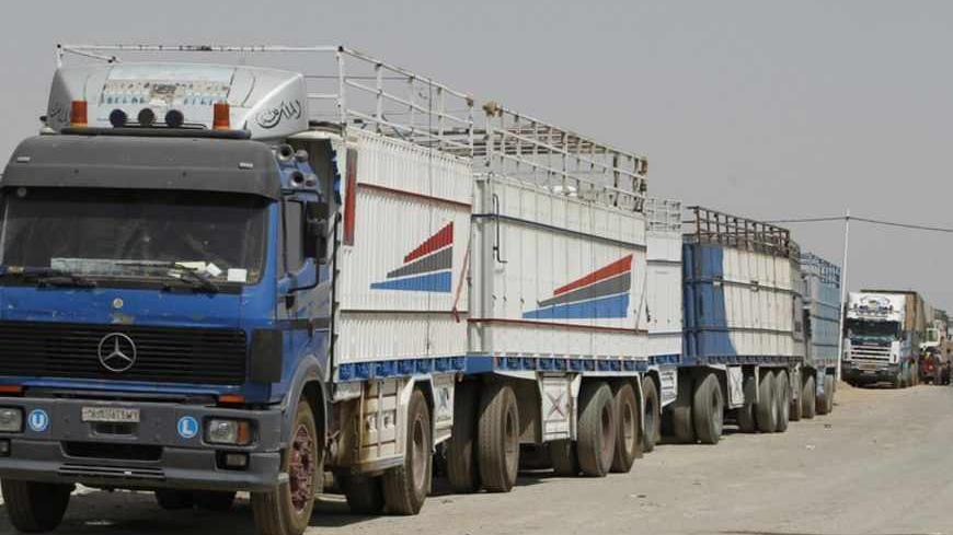 Syrian trucks are parked near the gate at the Rabia border crossing, the main border post between Iraq and Syria, July 24, 2012. REUTERS/Thaier al-Sudani (IRAQ - Tags: CONFLICT CIVIL UNREST CRIME LAW POLITICS) - RTR359VB