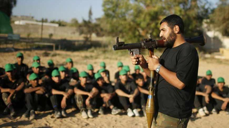 A Hamas militant teaches young Palestinians on how to use an rocket-propelled grenade (RPG) launcher at a military-style exercise run by Hamas during summer vacation in Gaza June 10, 2013. REUTERS/Mohammed Salem (GAZA - Tags: SOCIETY MILITARY) - RTX10ITJ
