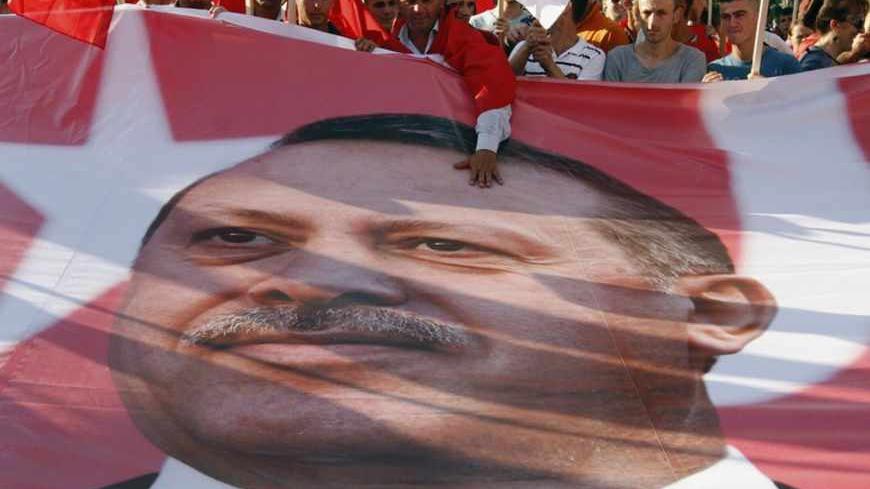 An Albanian man touches a banner with a picture of Turkish Prime Minister Tayyip Erdogan during a rally in support of Erdogan in Tirana June 19, 2013. REUTERS/Arben Celi (ALBANIA - Tags: POLITICS CIVIL UNREST) - RTX10TTO