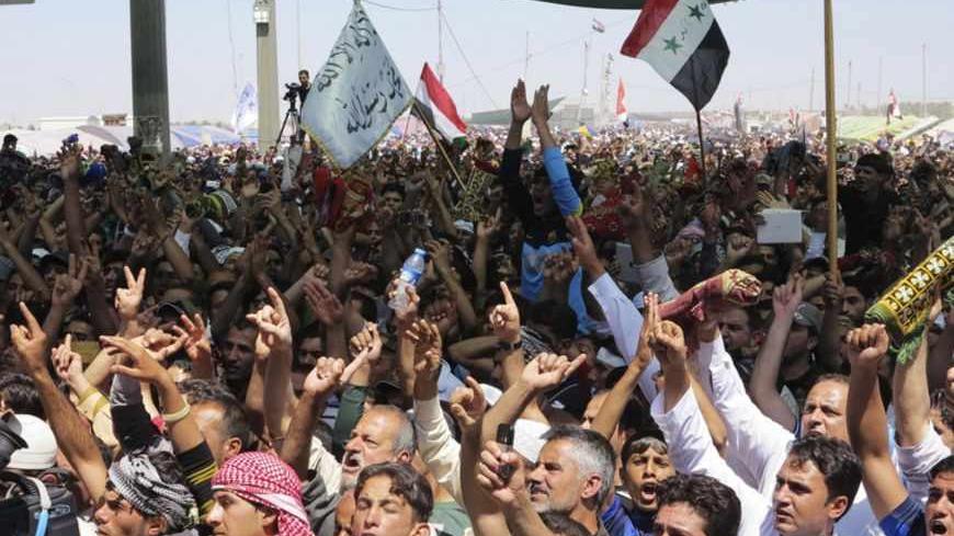 Sunni Muslims chant "Allahu Akbar", meaning "God is great", as they wave old Iraqi flags during an anti-government demonstration in Ramadi, 100 km (62 miles) west of Baghdad, April 26, 2013. Tens of thousands of Sunni Muslims poured onto the streets of Ramadi and Falluja in the western province of Anbar following Friday prayers, in protest against the perceived marginalisation of their sect since the U.S.-led invasion overthrew Saddam Hussein and empowered majority Shi'ites through the ballot box.  REUTERS/